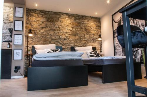 sypialnia z 2 łóżkami i kamienną ścianą w obiekcie Studio 20for2 Nähe Köln w mieście Bergisch Gladbach