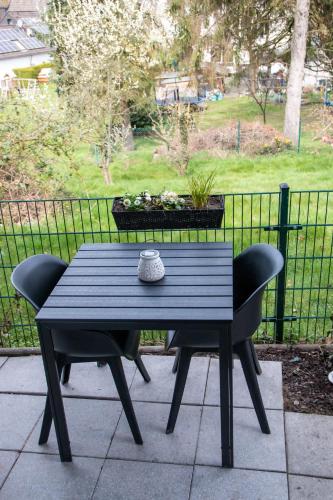 a black table with two chairs and a pot of flowers at Studio 20for2 Nähe Köln in Bergisch Gladbach