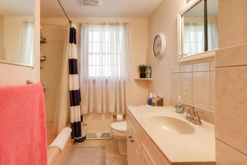 a bathroom with a sink and a toilet and a mirror at Picturesque Barnstable Rental with Deck and Backyard! in Barnstable