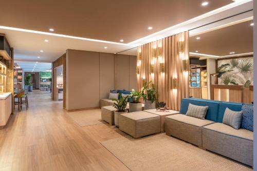 a living room with a blue couch and some plants at Fairfield by Marriott Medellin Sabaneta in Medellín