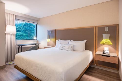 a hotel room with a large bed and a window at Fairfield by Marriott Medellin Sabaneta in Medellín