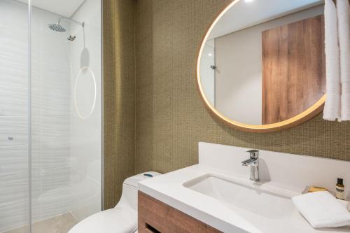 a bathroom with a sink and a mirror at Fairfield by Marriott Medellin Sabaneta in Medellín