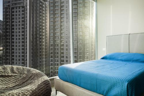 a bedroom with a blue bed and a large window at Moderno y amplio, 3 mn de San Pedro in Monterrey