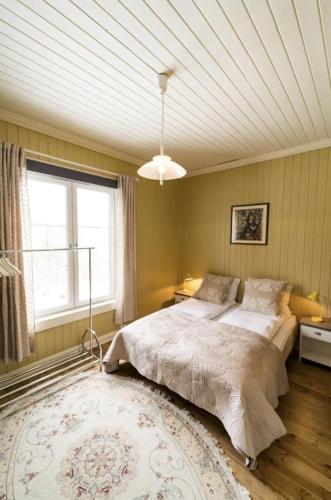 a bedroom with a large bed and a large window at Kollen Slottet in Oslo