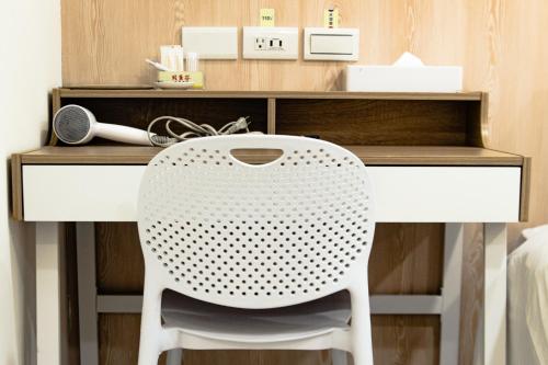 a white desk with a white chair in front of it at Beethoven Express Hotel in Zhongli