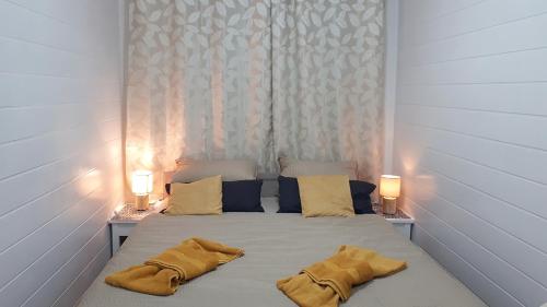 a bedroom with a bed with two yellow pillows at Penzión Florens, Nesvady in Nesvady