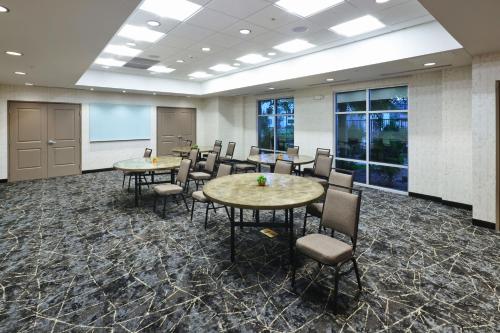 a conference room with tables and chairs and a screen at Residence Inn by Marriott Phoenix Chandler/South in Chandler