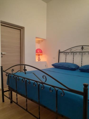 a blue bed in a bedroom with a door at La Coccola in Leporano