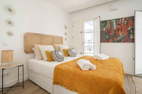 a bedroom with a large bed with towels on it at Casa Nova do Levante, perto do Mar in Olhão