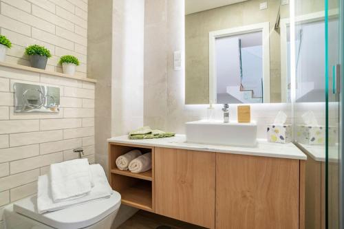 a bathroom with a sink and a toilet and a mirror at Casa Nova do Levante, perto do Mar, com estacionamento privativo in Olhão