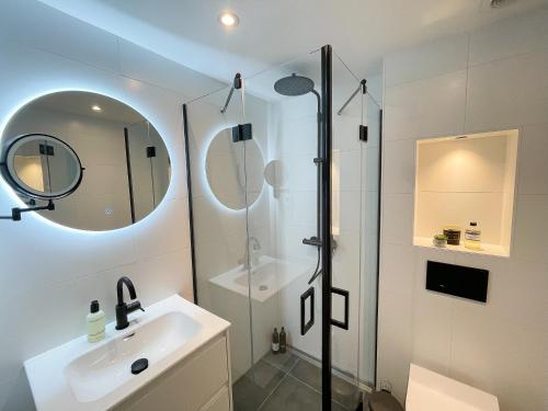 a bathroom with a shower and a sink and a mirror at La Siesta Noordwijk Zee in Noordwijk