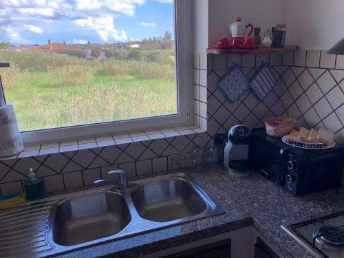 a kitchen counter with a sink and a window at CASA ORCHIDEA in Fiumicino