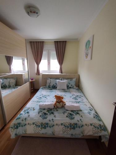 een slaapkamer met een bed met een teddybeer erop bij Apartman Mali Raj in Vrnjačka Banja