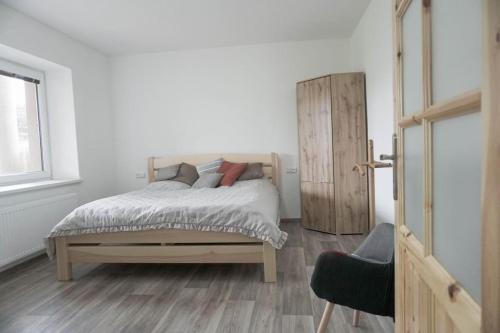 um quarto com uma cama e uma porta de madeira em Apartmán U Poštovských 