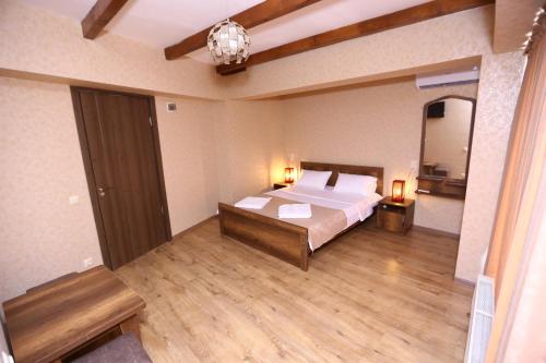 a large bedroom with a bed and a mirror at Hotel Traveler in Kutaisi