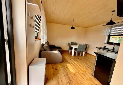 a living room with a couch and a table at Apartament na Ogrodowej - 2 sypialnie, ogród, taras, parking in Trzęsacz