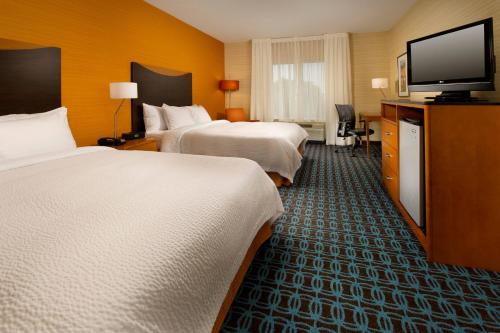 a hotel room with two beds and a flat screen tv at Fairfield Inn & Suites Germantown Gaithersburg in Germantown