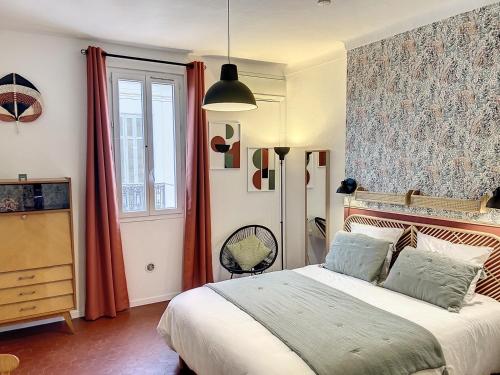 une chambre avec un grand lit et une fenêtre dans l'établissement Festival de palmiers, Plages-Congrès, Cocon de Calme au Cœur de Cannes, à Cannes