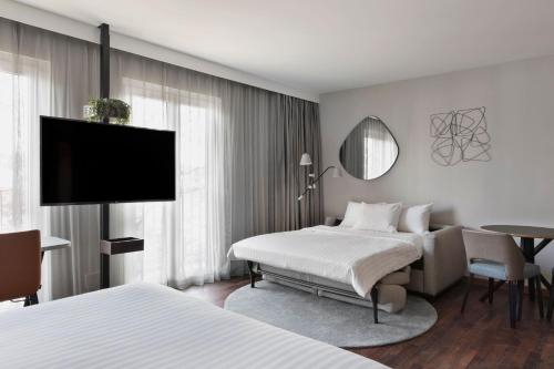 a hotel room with two beds and a flat screen tv at Residence Inn by Marriott Munich City East in Munich