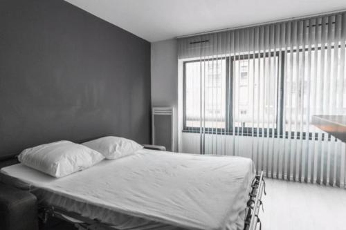 une chambre avec un lit et une grande fenêtre dans l'établissement MyAppart Ivry sur Seine / Bercy, à Ivry-sur-Seine