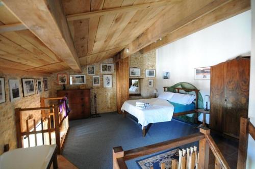 1 dormitorio con cama y techo de madera en LA SOURCE, en Gémozac