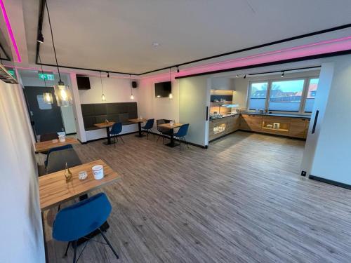 a large room with tables and chairs in a building at Meerzeit Strandhotel in Neuharlingersiel