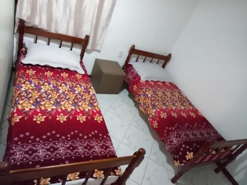 two beds sitting next to each other in a room at Hostel Da Penha in Vila Velha