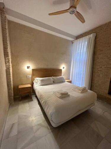 1 dormitorio con 1 cama y ventilador de techo en Casa Procurador Triana en Sevilla
