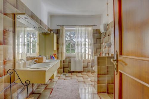 a bathroom with a sink and a large mirror at Villa Luce-Casa vacanza con vista panoramica mare. in Velletri