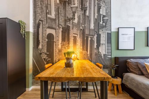 a dining room with a wooden table in front of a wall at Belle Histoire Middelburg in Middelburg