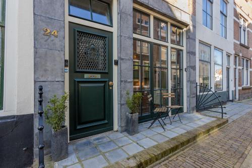 a green door on the side of a building at Belle Histoire Middelburg in Middelburg
