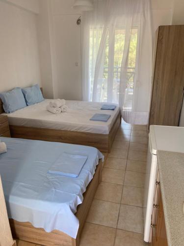 two beds sitting in a room with a kitchen at Jenny's Holiday Villas in Polychrono