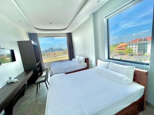 a hotel room with two beds and a large window at BITA HOTEL CẦN THƠ in Bình Thủy