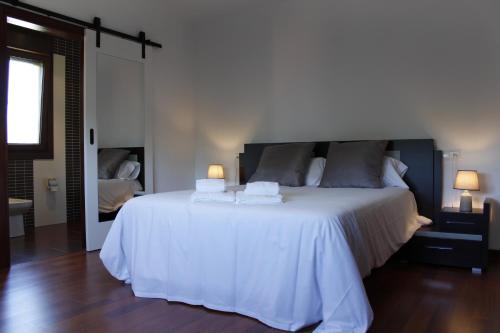 - une chambre avec un grand lit blanc et deux lampes dans l'établissement Sensacional Casa en Gondomar, à Gondomar