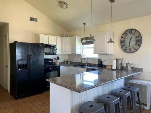 una cucina con frigorifero nero e armadietti bianchi di Sunshine DayDream by SurfBreakLLC a Surfside Beach