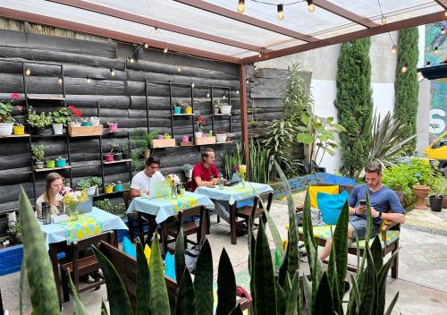 um grupo de pessoas sentadas em mesas em um jardim em Hostal Ciudad de Segorbe em Salento