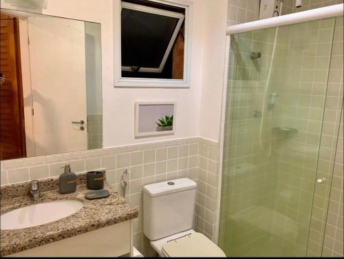 a bathroom with a toilet and a sink and a shower at Boulevard Riviera Flat - VISTA MAR E CLUBE in Riviera de São Lourenço