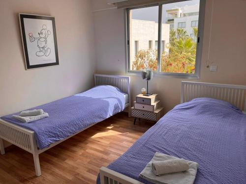 a bedroom with two beds and a window at Diamond Complex in Paphos