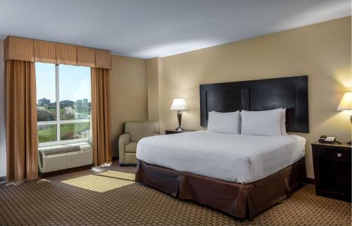 um quarto de hotel com uma cama grande e uma janela em Hyatt House Bentonville Rogers em Rogers