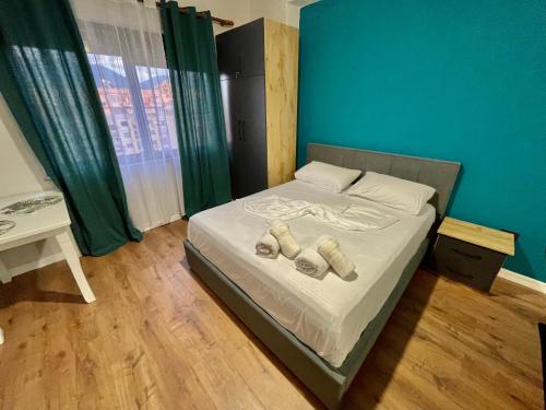 a bedroom with a bed with two slippers on it at Keon superb studio apartament in Tirana