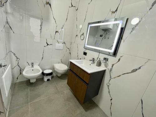a bathroom with a sink and a toilet and a mirror at Keon superb studio apartament in Tirana