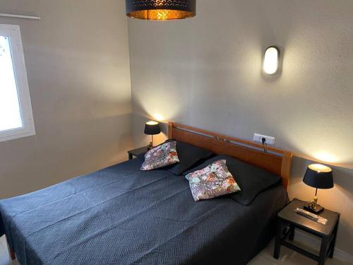 a bedroom with a blue bed with two pillows at Apartamento Europa con terraza in Blanes