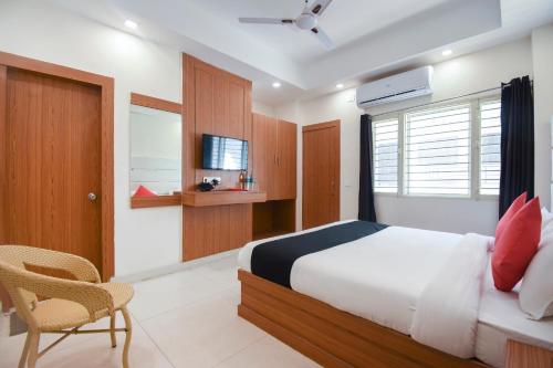 a bedroom with a bed and a chair and a television at Yours Pacific in Jhājra