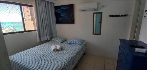1 dormitorio con 1 cama con 2 zapatillas en Studio Portal dos Corais apartamento 1003, en Recife