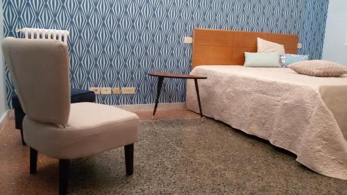 ローマにあるAd Vatican Suitesのベッドルーム1室(ベッド1台、椅子、テーブル付)