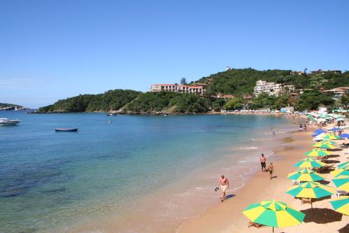 a group of people on a beach with umbrellas at Colonna Park Hotel in Búzios