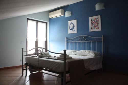 a bedroom with a bed with a blue wall at Casaci in Acireale