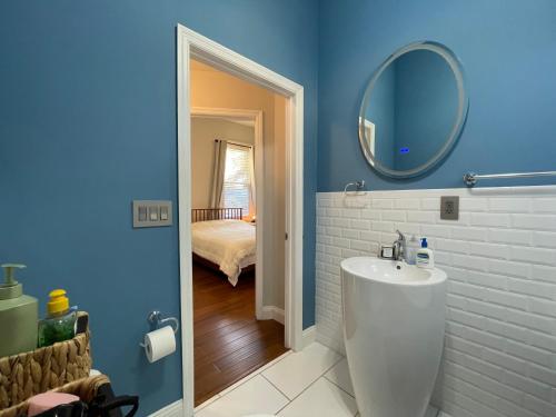 Baño azul con lavabo y espejo en Lovely Guesthouse in the Up-and-Coming Springfield, en Jacksonville