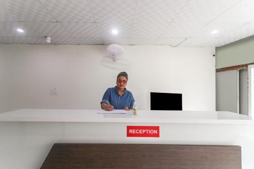 un homme debout à la réception dans un bureau dans l'établissement OYO Hotel Galaxy, à Faridabad