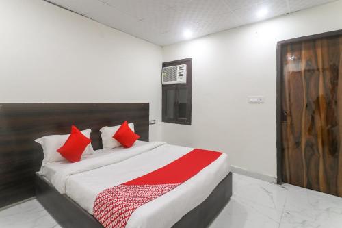 - une chambre avec un lit doté d'oreillers rouges dans l'établissement OYO Hotel Galaxy, à Faridabad